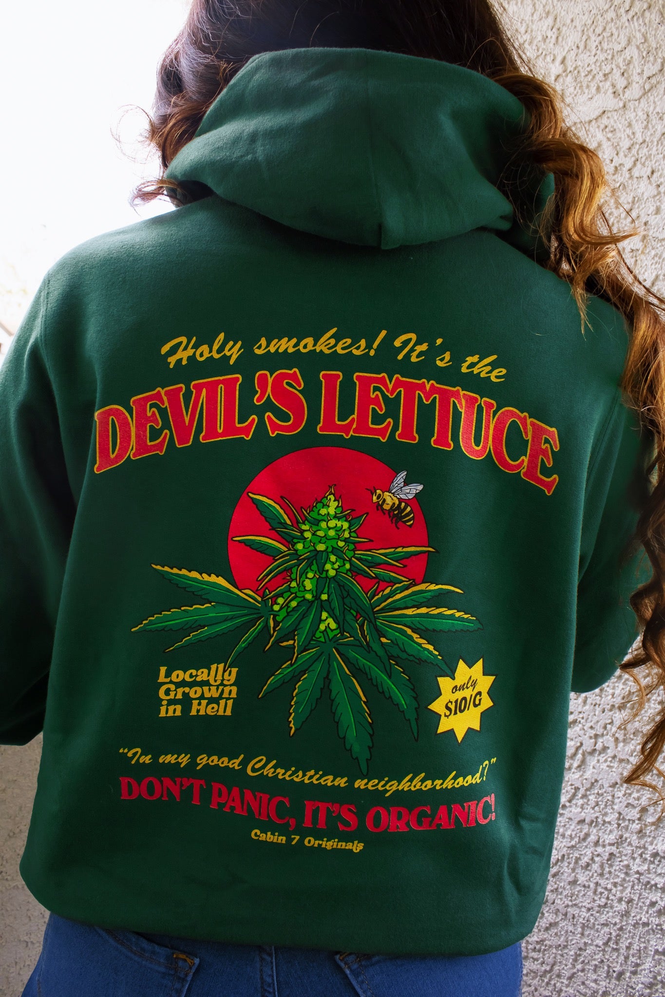 A dark green hoodie with a bright red and gold design of a cannabis plant that says "Devil's Lettuce". Hippie hoodie, 420 hoodie, stoner hoodie.