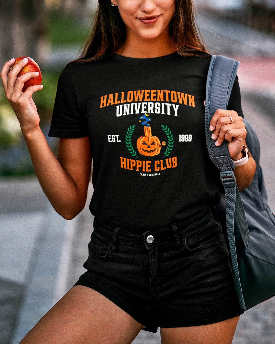 A black t-shirt with a stoner Halloween themed design that reads "Halloweentown University Hippie Club" and a pumpkin bong. Stoner shirts, Halloween apparel.