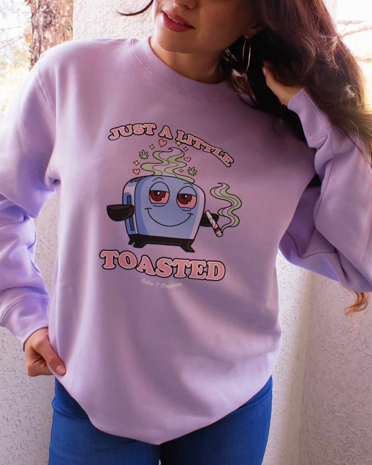 A light purple graphic T-shirt featuring a cartoon toaster with the text 'JUST A LITTLE TOASTED'.