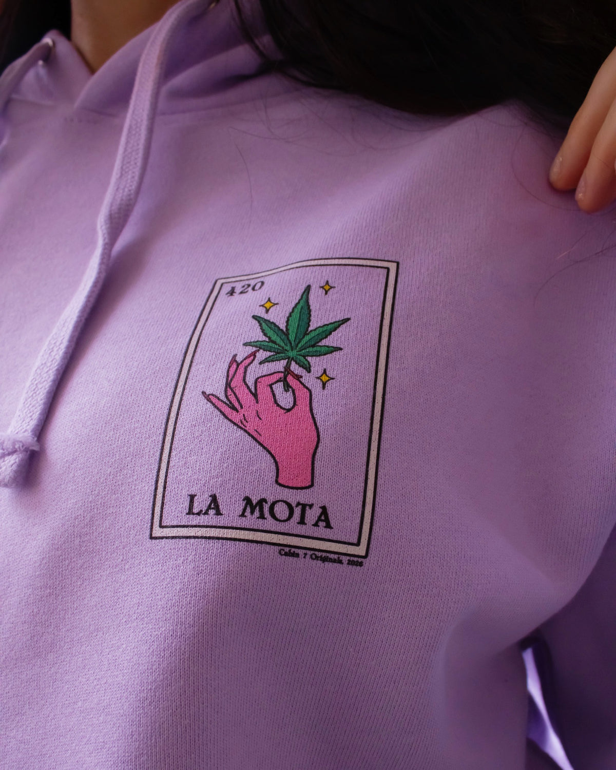 A light purple hoodie featuring a "La Mota" stoner loteria card on front. Stoner hoodie, stoner apparel, hippie apparel.