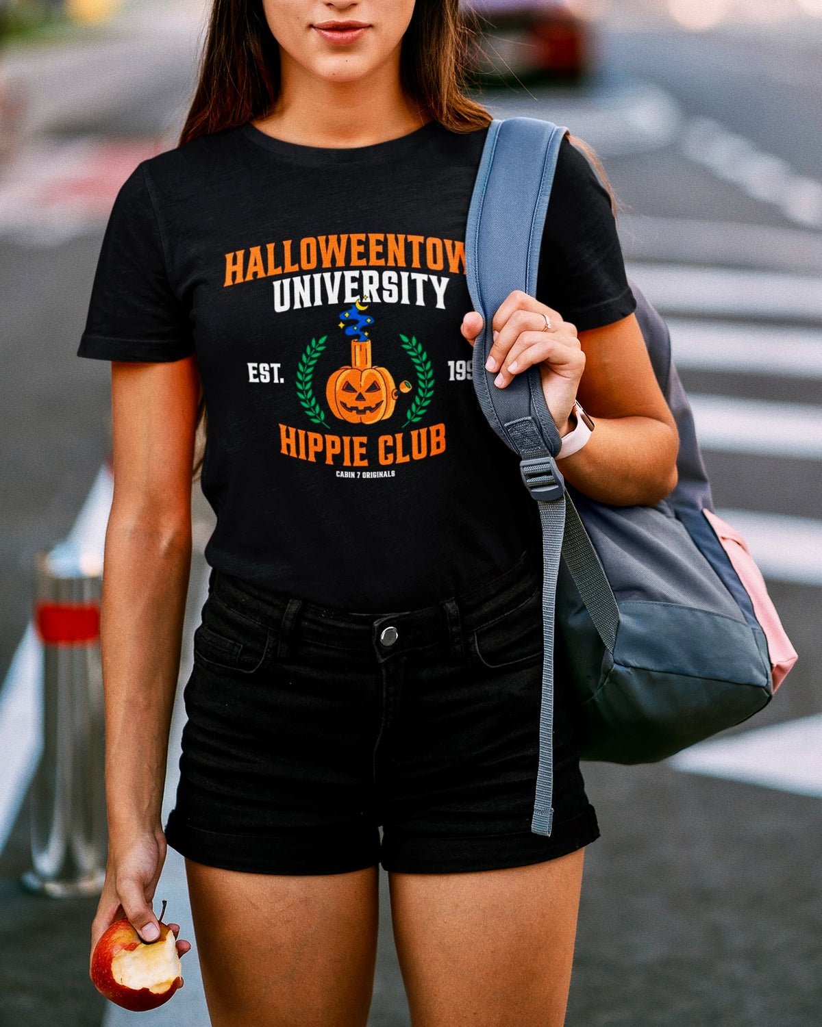A black t-shirt with a stoner Halloween themed design that reads "Halloweentown University Hippie Club" and a pumpkin bong. Stoner shirts, Halloween apparel.