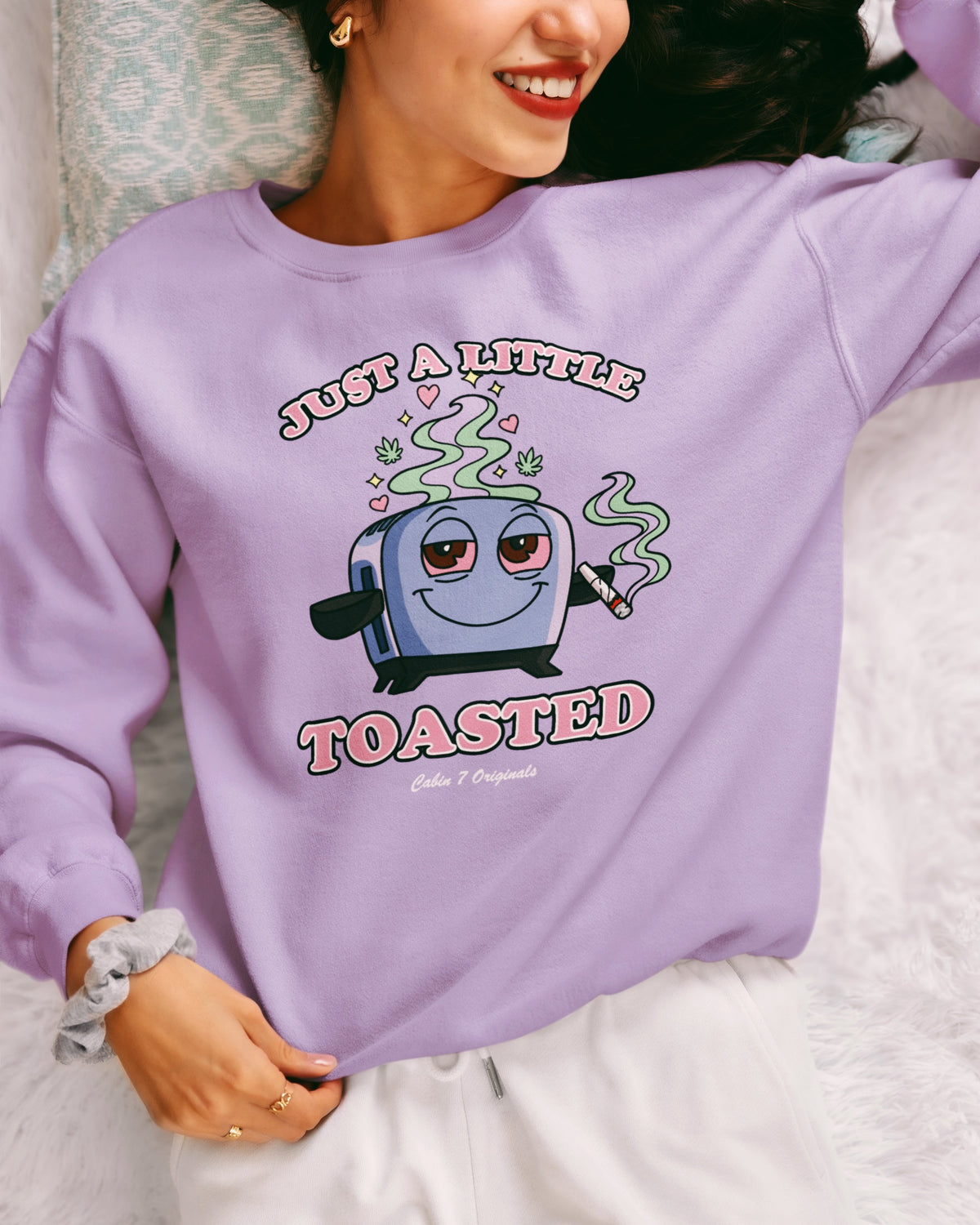 A light purple graphic T-shirt featuring a cartoon toaster with the text 'JUST A LITTLE TOASTED'.