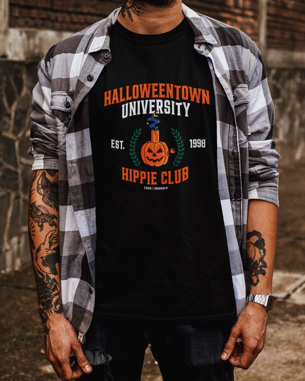 A black t-shirt with a stoner Halloween themed design that reads "Halloweentown University Hippie Club" and a pumpkin bong. Stoner shirts, Halloween apparel.