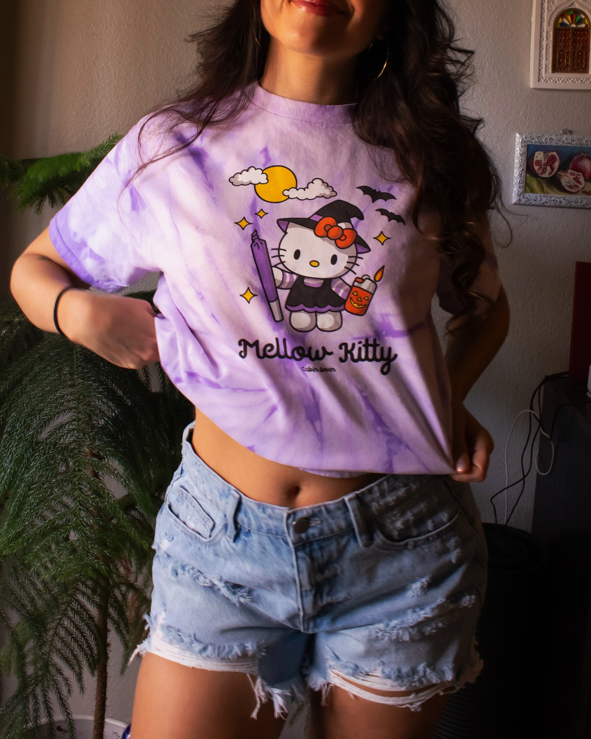 A purple tie-dye T-shirt featuring a Hello Kitty Halloween graphic with the text 'Mellow Kitty'.