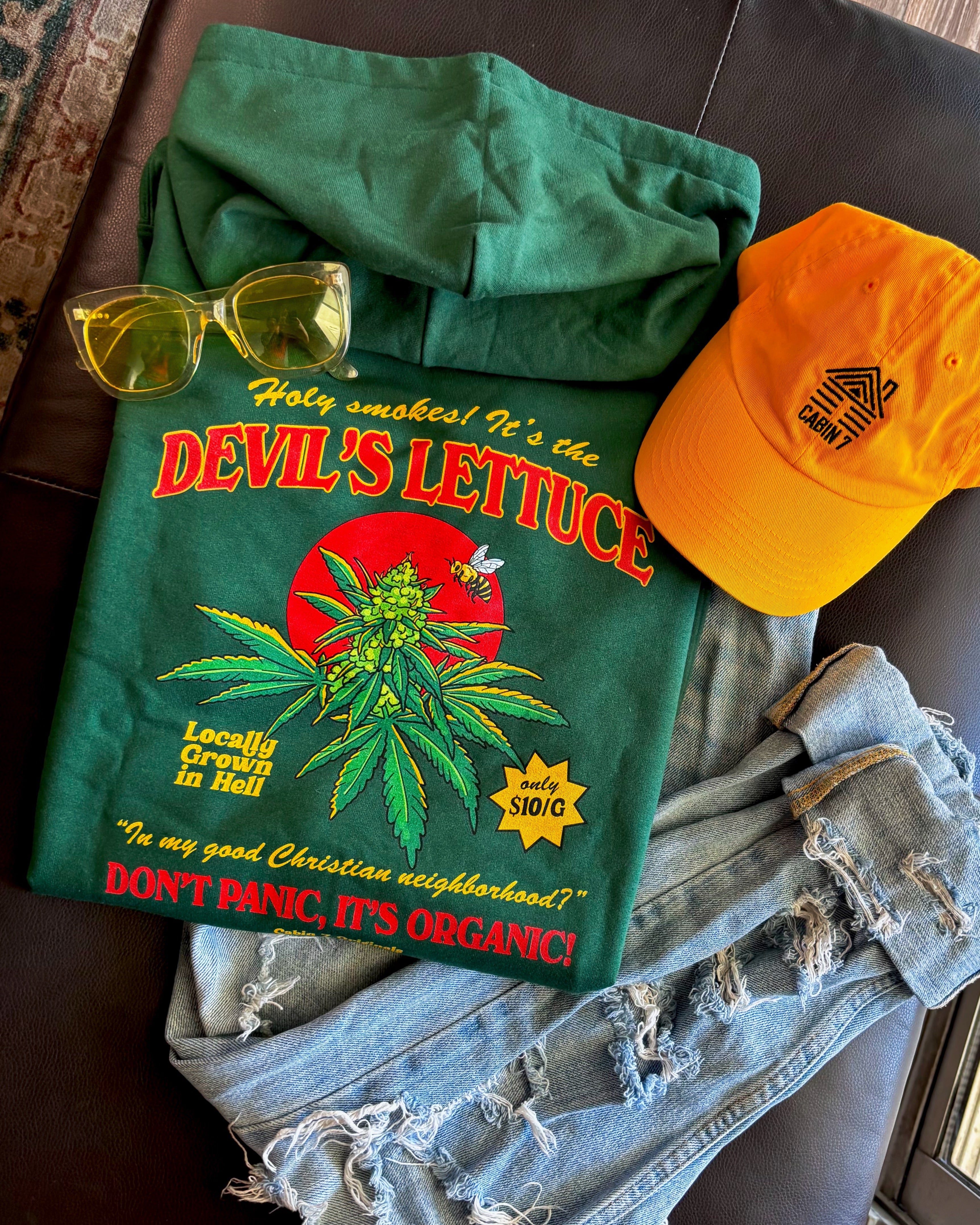 A dark green hoodie with a bright red and gold design of a cannabis plant that says "Devil's Lettuce". Hippie hoodie, 420 hoodie, stoner hoodie.