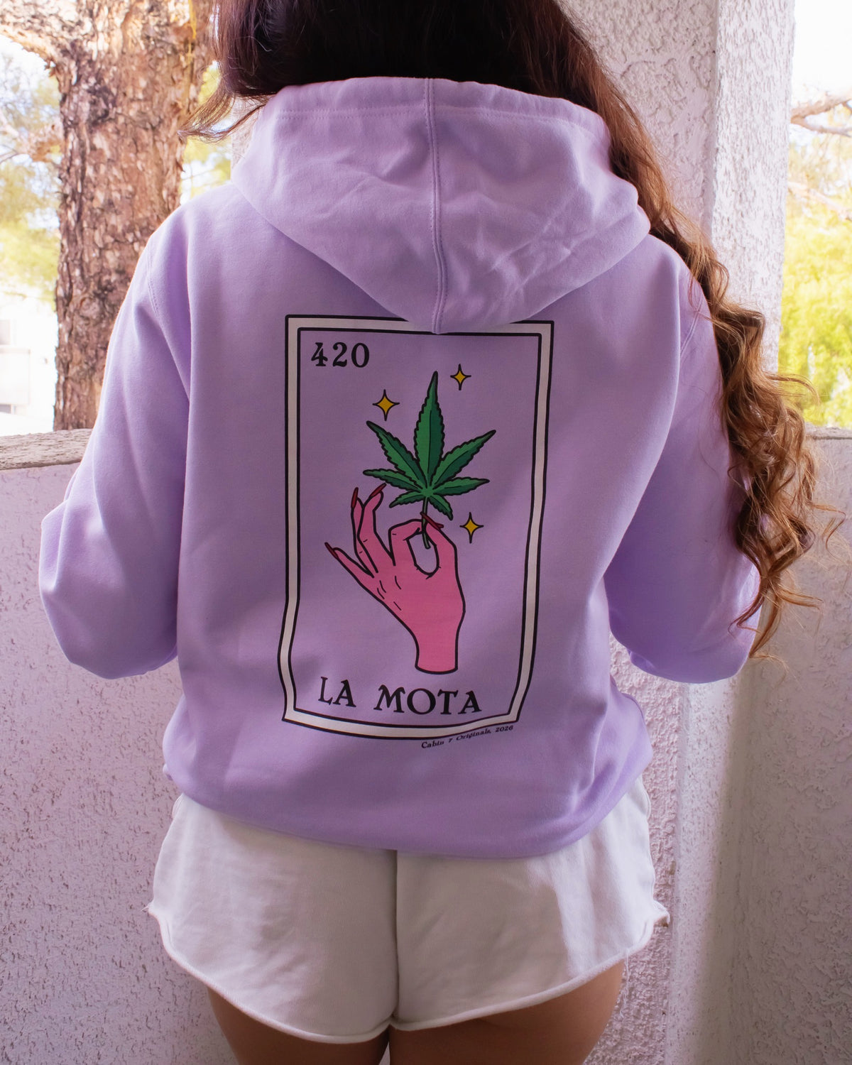 A light purple hoodie featuring a "La Mota" stoner loteria card on back. Stoner hoodie, stoner apparel, hippie apparel, 420 clothes.
