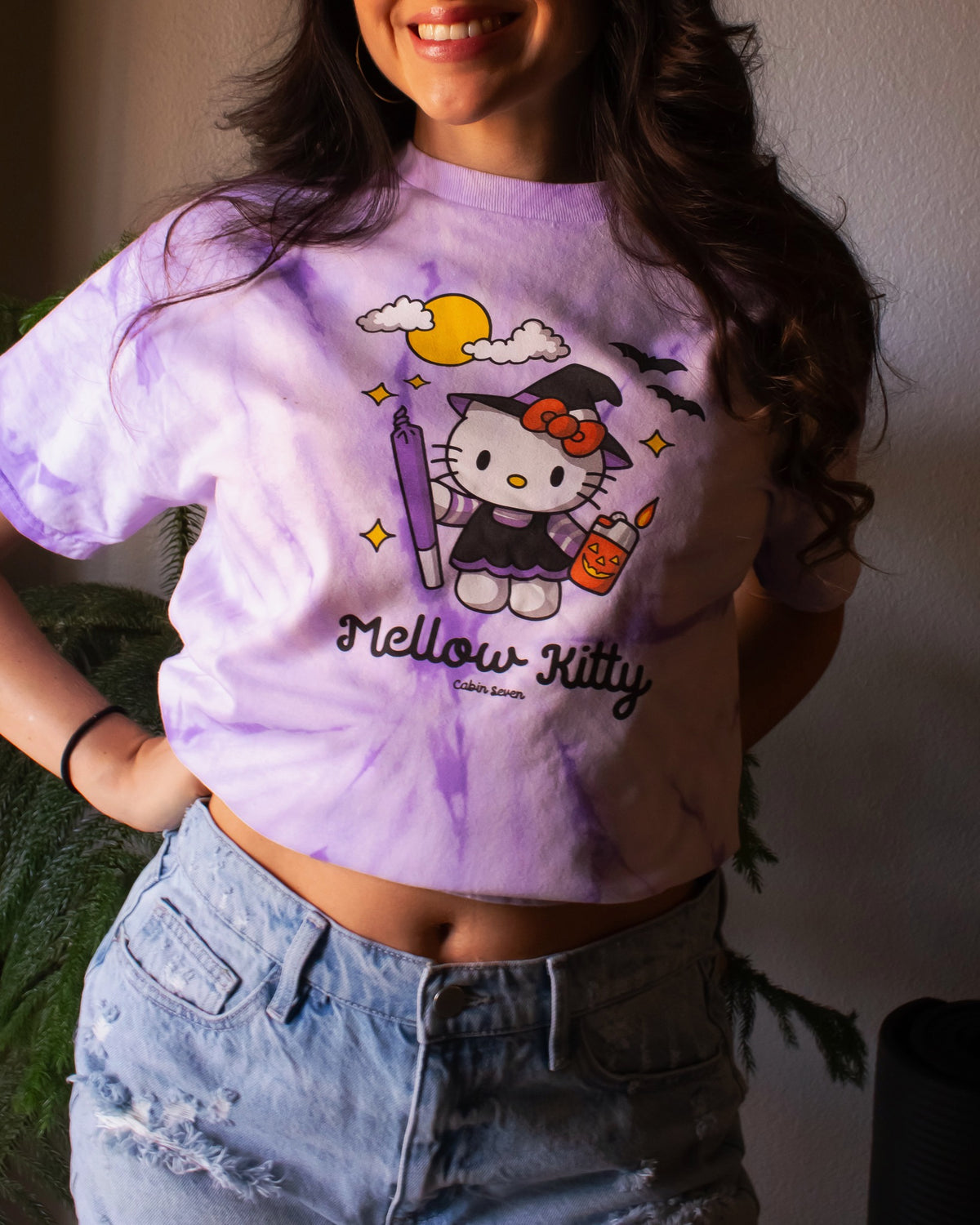 A purple tie-dye T-shirt featuring a Hello Kitty Halloween graphic with the text 'Mellow Kitty'.