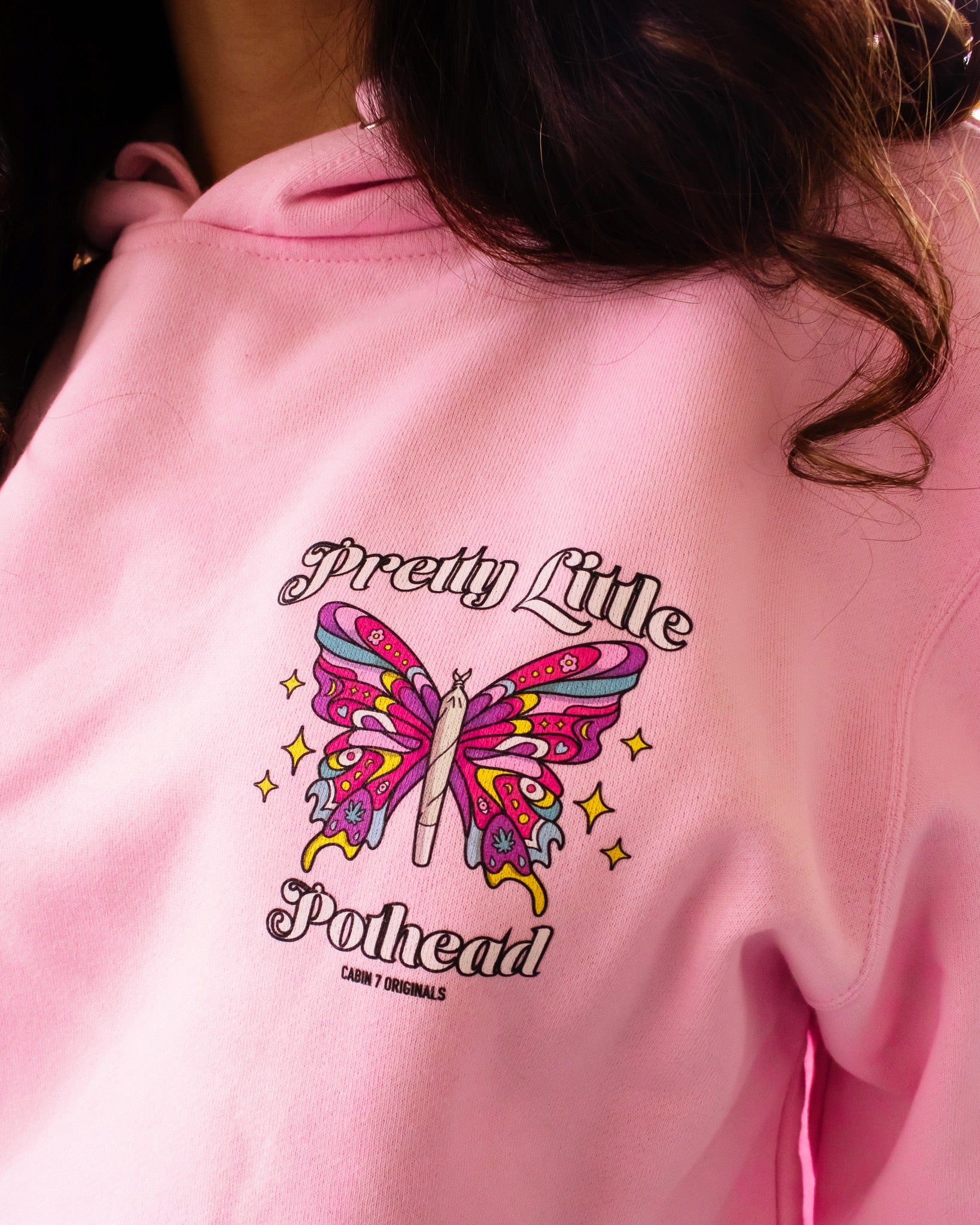 A baby pink hoodie with text "Pretty Little Pothead" and a colorful butterfly with a rolled joint as the body. Hippie girl apparel, stoner girl hoodie, 420 hoodie.
