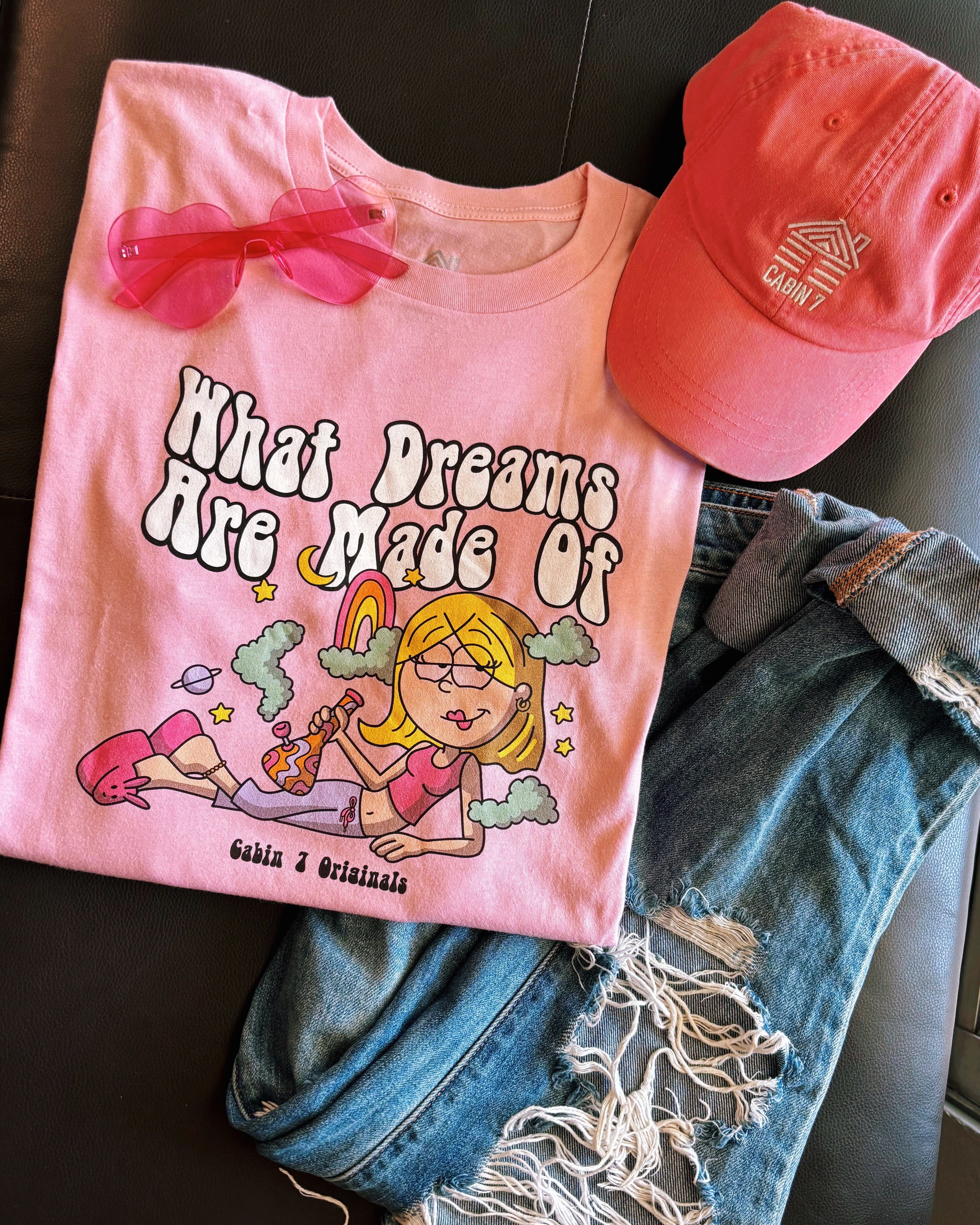 A pink t-shirt with a stoner Lizzie McGuire smoking a bong, that says "What Dreams Are Made Of".
