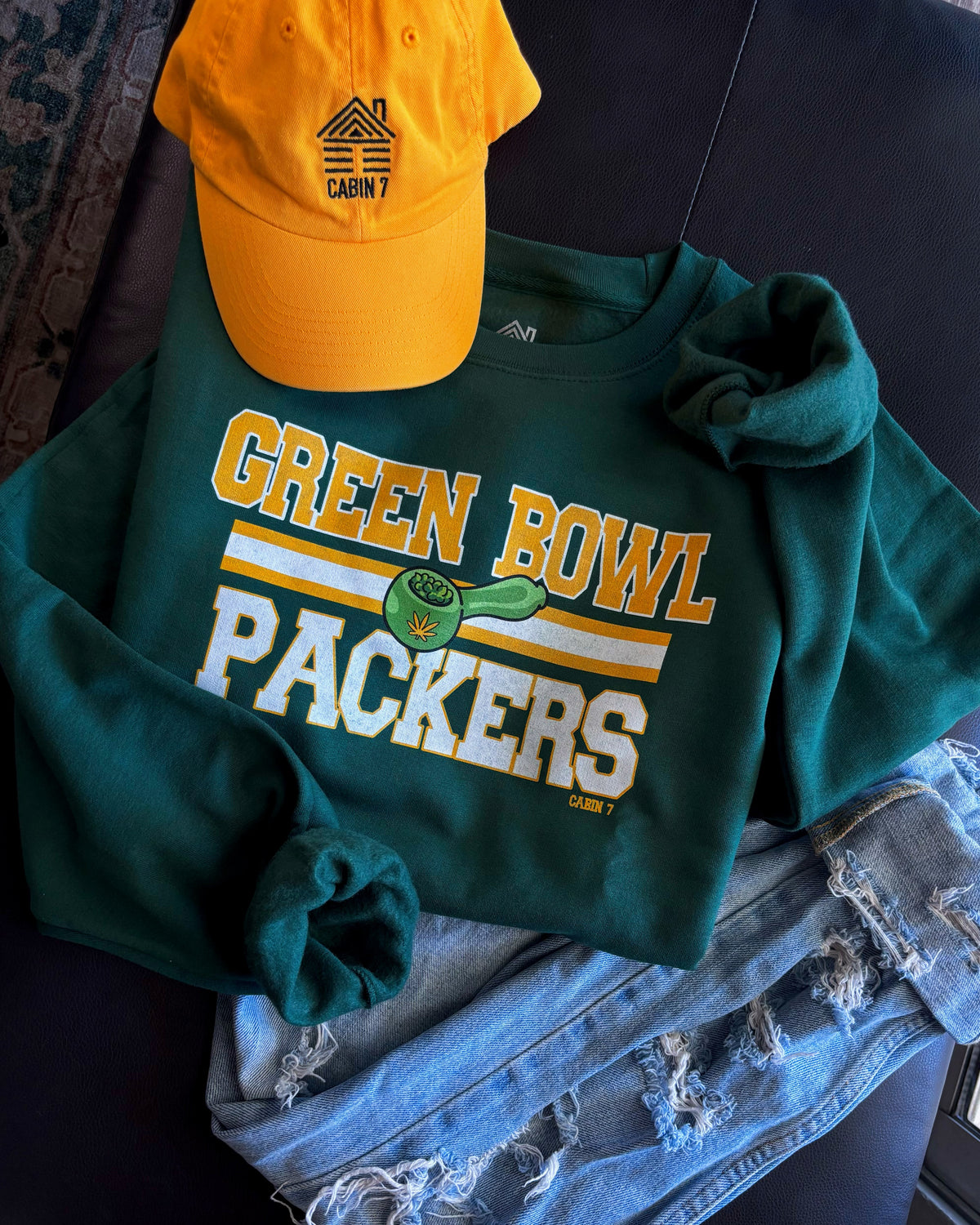A dark green crewneck sweatshirt with 'GREEN BOWL PACKERS' printed in yellow and white with a green football graphic. Green Bay Packers stoner apparel, 420 apparel, hippie apparel.