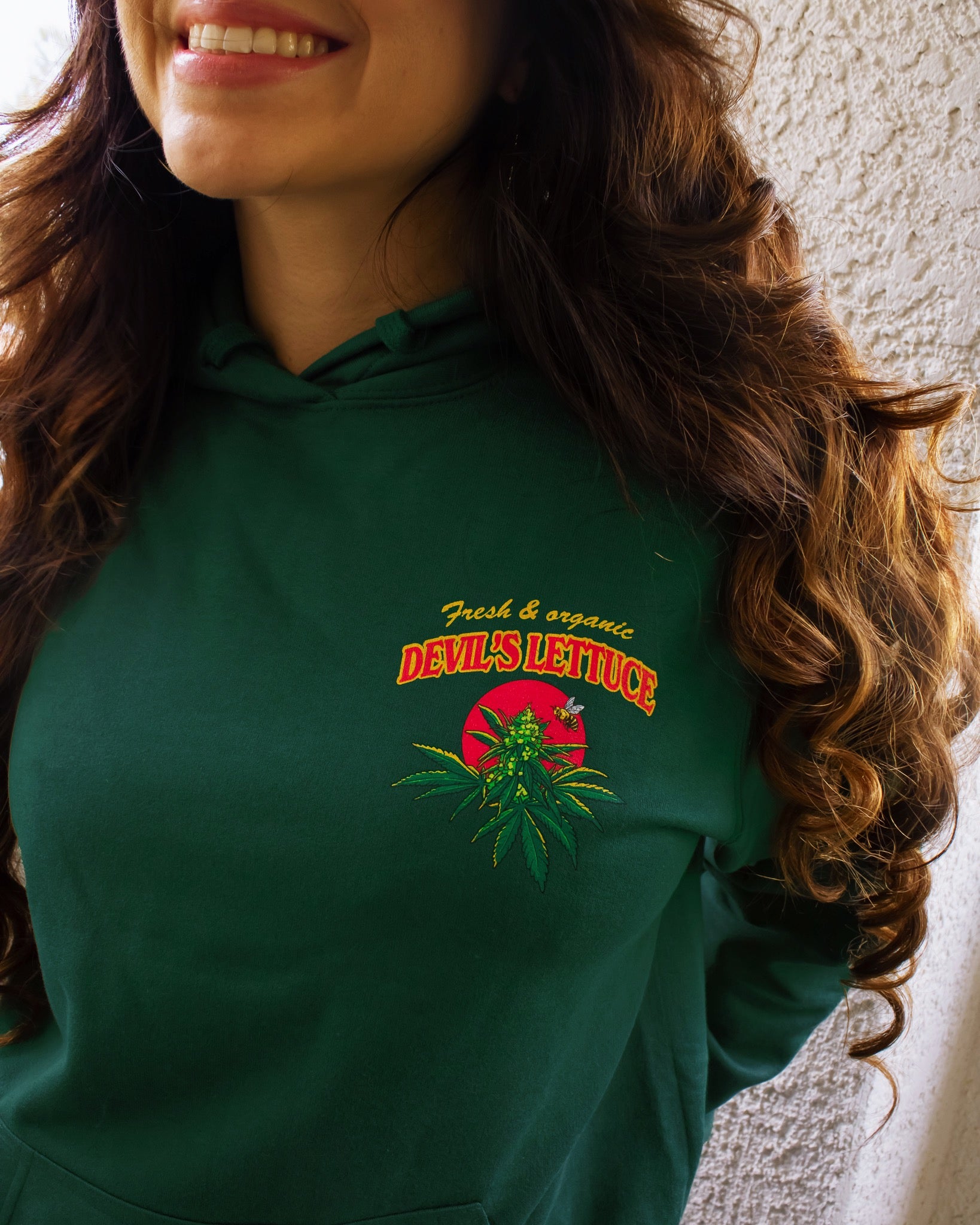 A dark green hoodie with a bright red and gold design of a cannabis plant that says "Devil's Lettuce". Hippie hoodie, 420 hoodie, stoner hoodie.