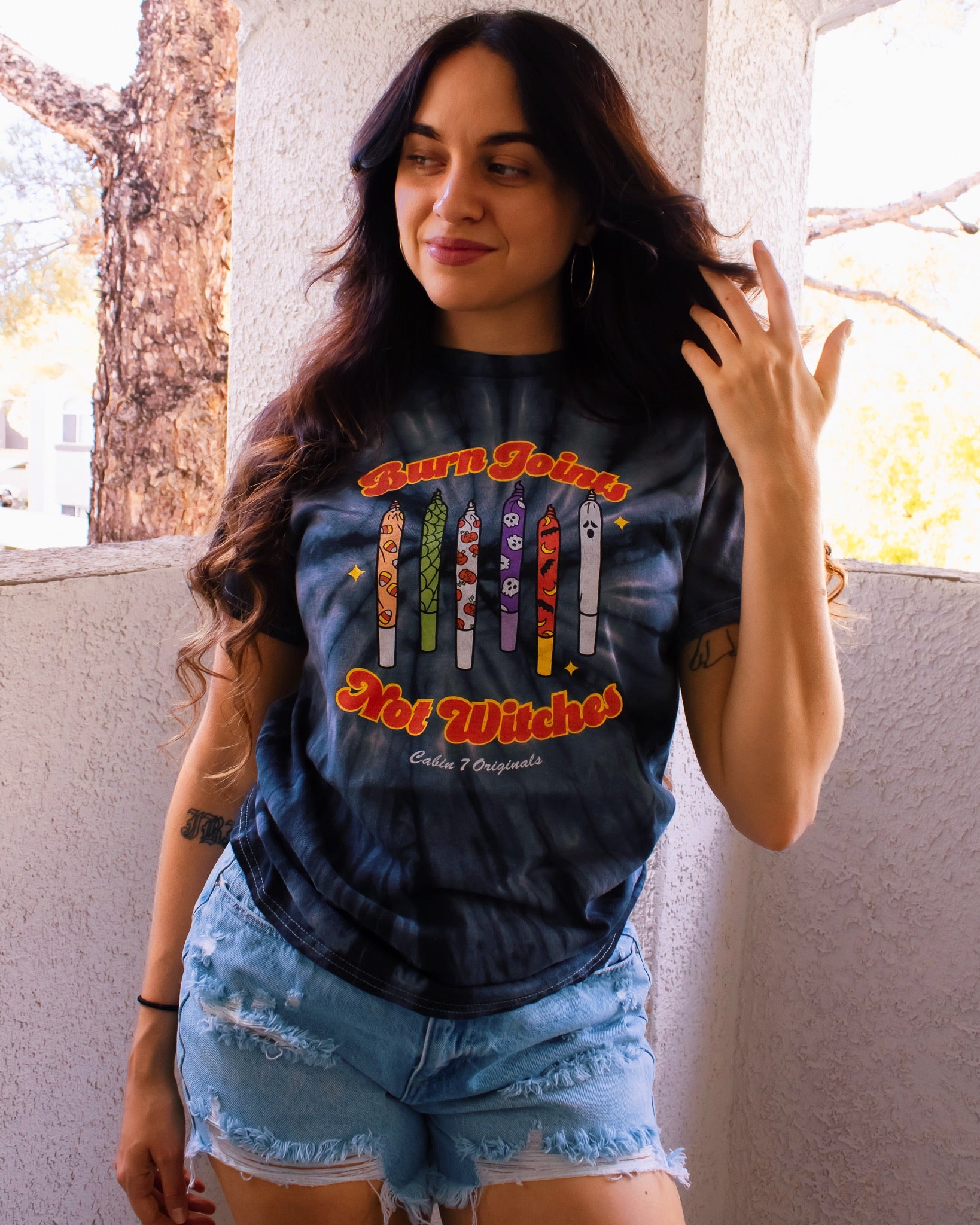Black tie-dye shirt with colorful halloween design on front, featuring multiple spooky joints and the text "Burn Joints Not Witches".