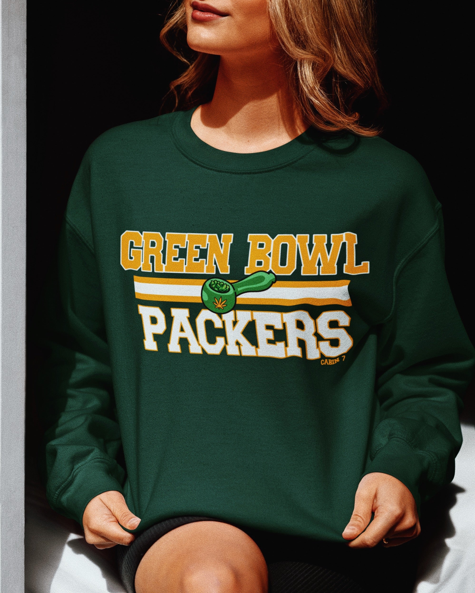 A dark green crewneck sweatshirt with 'GREEN BOWL PACKERS' printed in yellow and white with a green football graphic. Green Bay Packers stoner apparel, 420 apparel, hippie apparel.