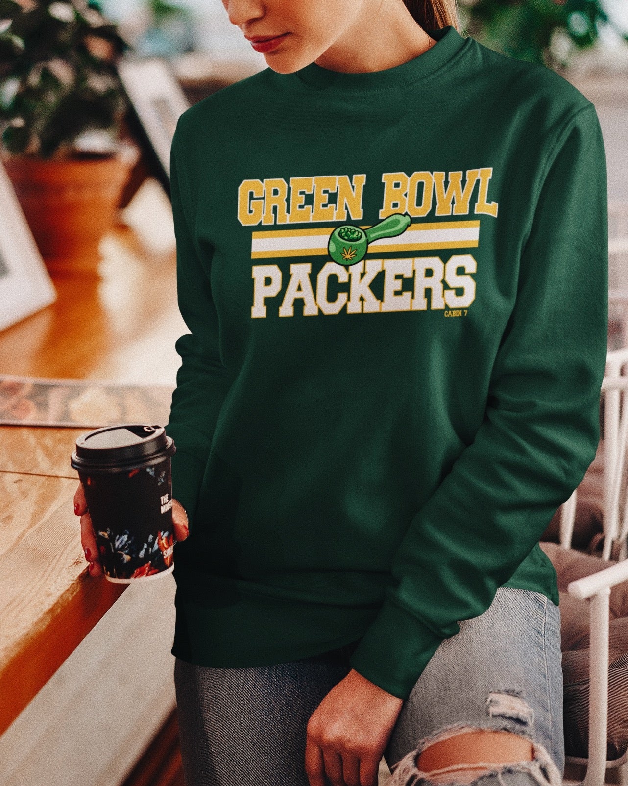 A dark green crewneck sweatshirt with 'GREEN BOWL PACKERS' printed in yellow and white with a green football graphic. Green Bay Packers stoner apparel, 420 apparel, hippie apparel.