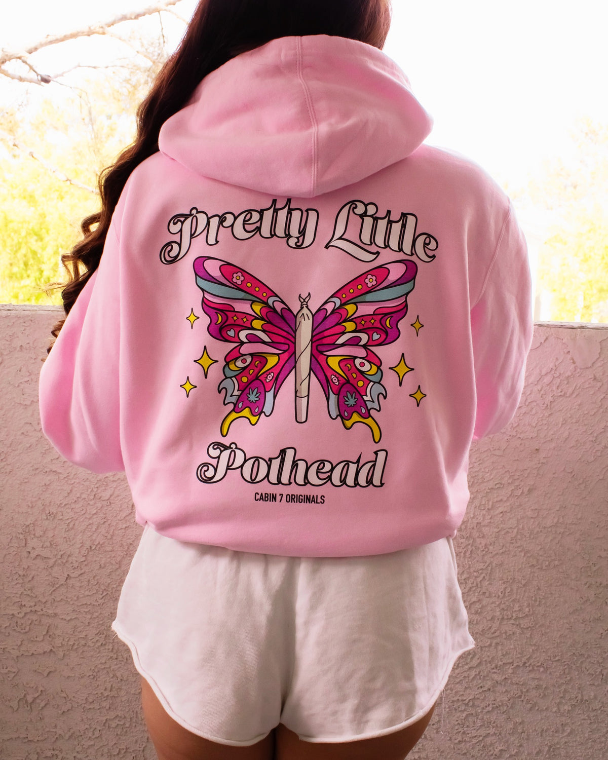 A baby pink hoodie with text "Pretty Little Pothead" and a colorful butterfly with a rolled joint as the body. Hippie girl apparel, stoner girl hoodie, 420 hoodie.