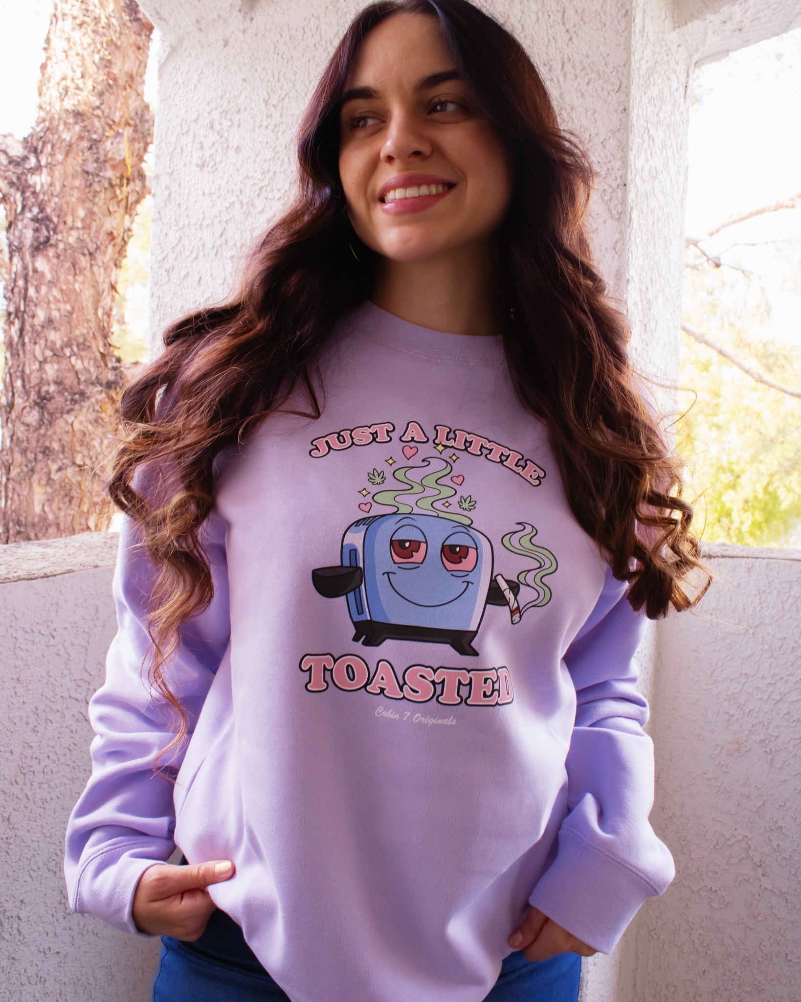 A light purple graphic T-shirt featuring a cartoon toaster with the text 'JUST A LITTLE TOASTED'.