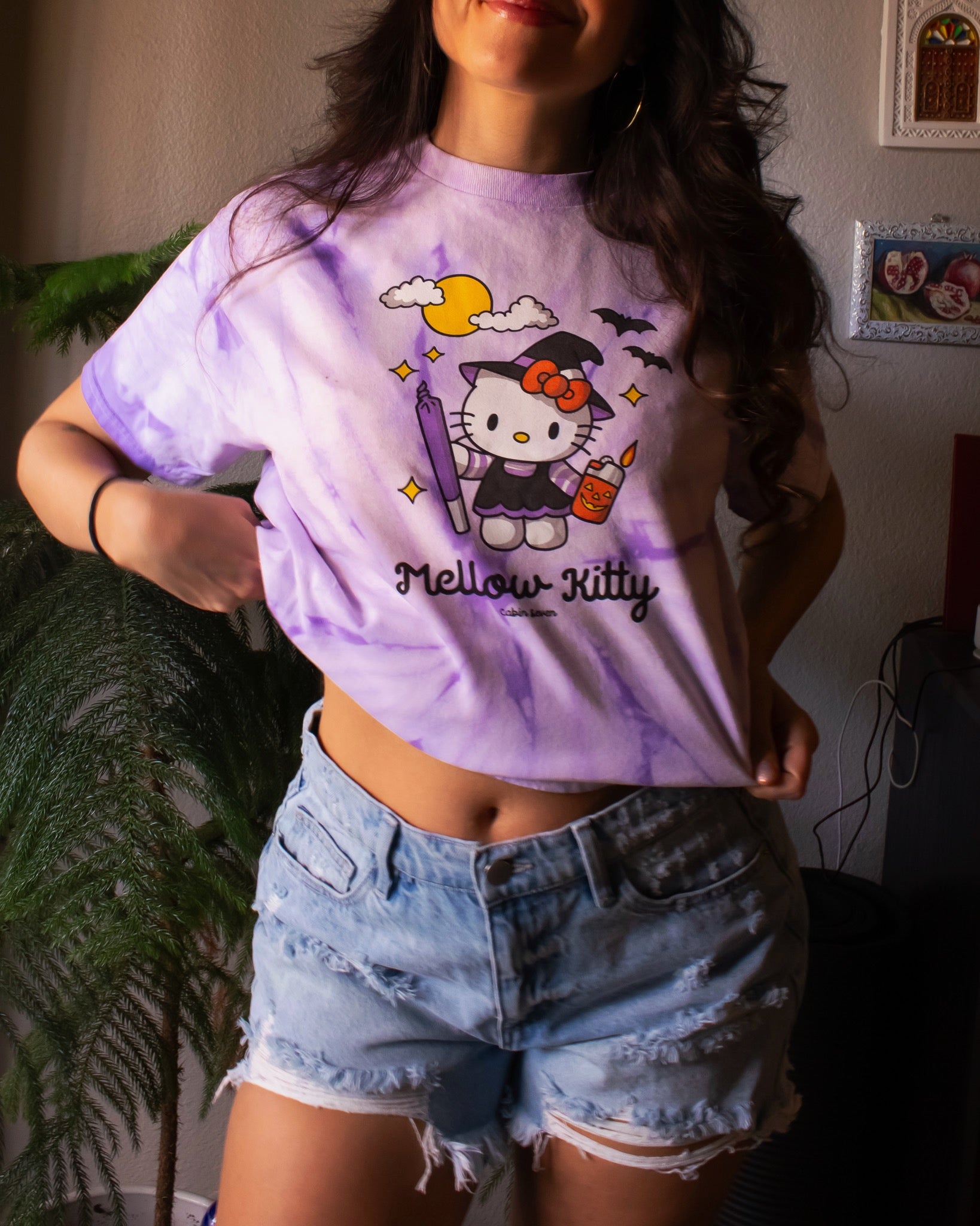 A purple tie-dye T-shirt featuring a Hello Kitty Halloween graphic with the text 'Mellow Kitty'.